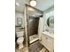Updated bathroom featuring a modern shower with gray tile, a new vanity, and updated light fixtures at 106 S Denny St, Indianapolis, IN 46201
