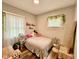 Bright bedroom with light walls, a cozy bed, a desk and natural light from the window, creating a comfortable space at 106 S Denny St, Indianapolis, IN 46201