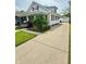 View of a charming home with a long driveway leading to a detached garage at 106 S Denny St, Indianapolis, IN 46201