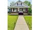 Charming home with a well-maintained lawn, walkway, and a welcoming front porch at 106 S Denny St, Indianapolis, IN 46201