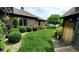 Well-maintained backyard with lush green grass, mature landscaping, and brick detail on the house at 1102 Redwood Dr, Brownsburg, IN 46112