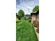 Beautifully landscaped backyard with lush lawn, mature trees, and a charming pergola-covered deck at 1102 Redwood Dr, Brownsburg, IN 46112