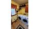 Bright laundry room with modern washer and dryer, storage cabinet, and window at 1102 Redwood Dr, Brownsburg, IN 46112