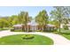 Beautiful brick home with an American flag, a circular driveway, and lush green landscaping at 1105 Deer Creek Dr, Anderson, IN 46011