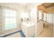 Cozy bathroom featuring floral wallpaper, a vanity with sink, and natural light streaming through the window at 1105 Deer Creek Dr, Anderson, IN 46011