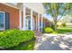 Close-up view of the brick home's entrance with a porch, columns, and lush green bushes at 1105 Deer Creek Dr, Anderson, IN 46011