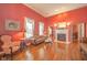 Elegant living room featuring red walls, hardwood floors, fireplace, and an abundance of natural light at 1105 Deer Creek Dr, Anderson, IN 46011
