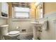 Well-lit bathroom featuring a pedestal sink, tiled floor, and white wainscoting at 114 E 44Th St, Indianapolis, IN 46205