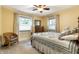 Sunlit bedroom with two windows, hardwood floors, ceiling fan, and charming furniture at 114 E 44Th St, Indianapolis, IN 46205