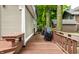 Relaxing backyard wooden deck with a grill, built-in bench, and lush green surroundings at 114 E 44Th St, Indianapolis, IN 46205