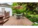 Wooden deck features a seating area with an umbrella and lush garden views at 114 E 44Th St, Indianapolis, IN 46205