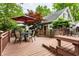 A wooden deck with seating arrangement, shaded by a colorful umbrella, offering a relaxing outdoor living space at 114 E 44Th St, Indianapolis, IN 46205