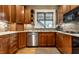 Kitchen featuring stainless steel appliances, granite countertops, and wood cabinetry at 114 E 44Th St, Indianapolis, IN 46205