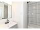 This bathroom features a sleek gray vanity, stylish lighting, and a subway-tiled shower at 11816 Wapiti Way, Noblesville, IN 46060