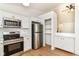 Well-lit kitchen with stainless steel appliances and white cabinets, complemented by light wood flooring at 11816 Wapiti Way, Noblesville, IN 46060