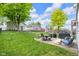 Spacious backyard with green lawn, patio furniture, grill, and detached garages at 1311 E Michigan St, Indianapolis, IN 46202