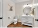 Chic half bathroom with modern vanity, round mirror, and stylish artwork on the wall at 1311 E Michigan St, Indianapolis, IN 46202