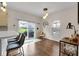 Bright dining area features modern light fixture, hardwood flooring, and access to the backyard at 1311 E Michigan St, Indianapolis, IN 46202