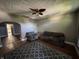 Living room with dark gray walls, plush seating, patterned rug, and a ceiling fan, ready for renovation at 1314 Laurel St, Indianapolis, IN 46203