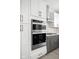 Close-up of the oven and cooktop in the modern kitchen with gray cabinets and brass hardware at 1322 Colere Pl, Indianapolis, IN 46203