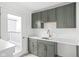 Stylish kitchenette featuring sleek gray cabinetry, quartz countertops, and modern hardware fixtures at 1322 Colere Pl, Indianapolis, IN 46203