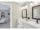 Bathroom vanity with double sinks, white cabinets, black hardware, and view to the bedroom at 1429 Deloss St, Indianapolis, IN 46201