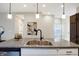 Granite countertops highlight the large kitchen island with stainless steel sink and pendant lighting at 1429 Deloss St, Indianapolis, IN 46201