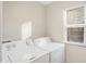 Bright laundry room with a full-size Amana washer and dryer near a window at 1429 Deloss St, Indianapolis, IN 46201
