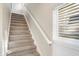 Carpeted staircase leading to the upper level, illuminated by a window with blinds at 1429 Deloss St, Indianapolis, IN 46201