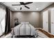 Bedroom featuring a striped bed, dark wood flooring, ceiling fan, and natural light, perfect for relaxation at 1604 Stacy Lynn Dr, Indianapolis, IN 46231