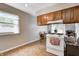 Modern kitchen with wood cabinets, white appliances, and vinyl flooring at 1604 Stacy Lynn Dr, Indianapolis, IN 46231