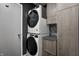 Efficient laundry room showcasing stacked washer and dryer units, complemented by neutral cabinets and countertop at 1604 Stacy Lynn Dr, Indianapolis, IN 46231