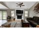 Spacious living room with vaulted ceilings, white brick fireplace, ceiling fan, and sliding glass door at 1604 Stacy Lynn Dr, Indianapolis, IN 46231