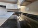 Close up of kitchen's striking dark countertops with a modern sink and white cabinetry at 1614 Dayton Ave, Indianapolis, IN 46203
