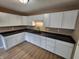 Kitchen with white cabinets, dark countertops, and hard surface floors at 1614 Dayton Ave, Indianapolis, IN 46203