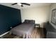 Bedroom featuring dark accent wall with a bed, nightstand and dresser on laminate wood flooring at 170 Briar Hill Dr, Whiteland, IN 46184