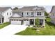 Charming two-story home featuring a three-car garage, brick accents, and a well-manicured lawn at 19442 Honeylocust Glen, Noblesville, IN 46062
