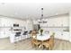 Kitchen and dining area, featuring white cabinets, island seating, and stainless steel appliances at 19442 Honeylocust Glen, Noblesville, IN 46062
