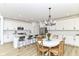Modern eat-in kitchen with white cabinets, a center island, stainless appliances and a stylish light fixture at 19442 Honeylocust Glen, Noblesville, IN 46062
