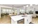 Open-concept kitchen features stainless appliances, a breakfast bar, seamlessly flowing into the living space at 19442 Honeylocust Glen, Noblesville, IN 46062