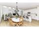 Bright open-concept living and dining area with wood floors, fireplace, and modern white kitchen at 19442 Honeylocust Glen, Noblesville, IN 46062