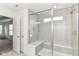 Bright bathroom with a glass-enclosed shower with bench and neutral walls at 19442 Honeylocust Glen, Noblesville, IN 46062