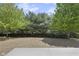 Backyard view from concrete patio showcasing lush trees with a view of sky and clouds at 19570 Forsythe Dr, Noblesville, IN 46060