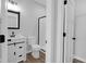 Modern bathroom with white vanity, black hardware, and a sleek, glass-enclosed shower at 19570 Forsythe Dr, Noblesville, IN 46060