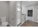 Modern bathroom featuring a toilet, glass shower, marble surround and decorative accent wall at 19570 Forsythe Dr, Noblesville, IN 46060