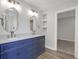 Bathroom featuring a blue double vanity, marble shower, and an entrance to closet at 19570 Forsythe Dr, Noblesville, IN 46060
