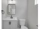 Stylish powder room with modern fixtures, gray vanity, and rectangular mirror at 19570 Forsythe Dr, Noblesville, IN 46060