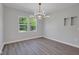 The dining room features modern chandelier, luxury vinyl plank floors, and two windows at 19570 Forsythe Dr, Noblesville, IN 46060