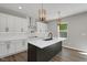 Modern kitchen featuring white cabinets, black island, and stainless steel appliances at 19570 Forsythe Dr, Noblesville, IN 46060