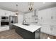 Modern kitchen boasts a spacious island, stainless steel appliances, and white cabinetry with black hardware at 19570 Forsythe Dr, Noblesville, IN 46060